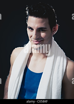 Portrait of smiling caucasian male en sportswear, looking at camera et souriant sur fond noir. Banque D'Images