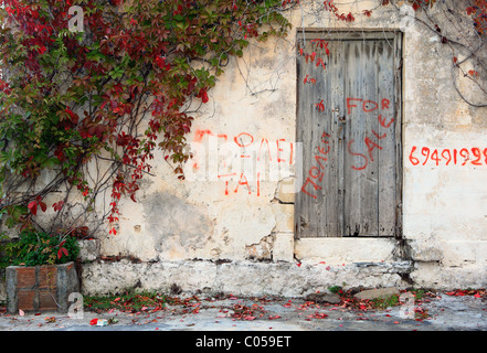 Une végétation property on Crete, Grèce, avec 'à vendre' griffonnés messages dessus et une partie d'un numéro Banque D'Images