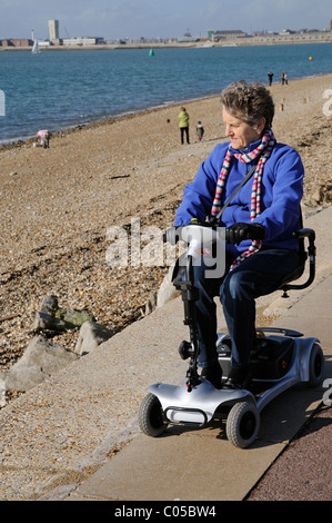 Scooter de mobilité d'équitation de l'utilisateur une machine fonctionnant sur batterie ultra léger sur le front de mer de Southsea le sud de l'Angleterre, Royaume-Uni Banque D'Images