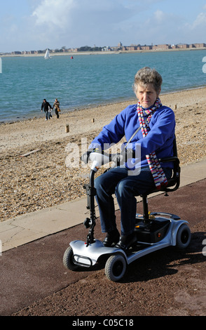 Scooter de mobilité d'équitation de l'utilisateur une machine fonctionnant sur batterie ultra léger sur le front de mer de Southsea le sud de l'Angleterre, Royaume-Uni Banque D'Images