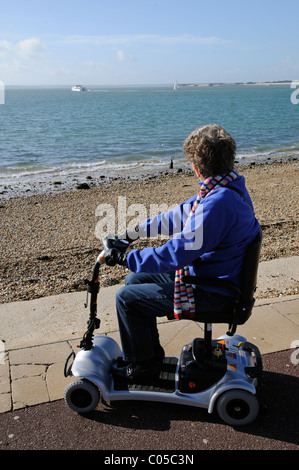 Scooter de mobilité d'équitation de l'utilisateur une machine fonctionnant sur batterie ultra léger sur le front de mer de Southsea le sud de l'Angleterre, Royaume-Uni Banque D'Images