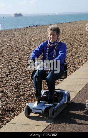 Scooter de mobilité d'équitation de l'utilisateur une machine fonctionnant sur batterie ultra léger sur le front de mer de Southsea le sud de l'Angleterre, Royaume-Uni Banque D'Images