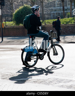 Un cycliste en utilisant le nouveau Londres Location de voitures. UK Banque D'Images