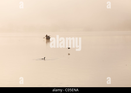 Les pêcheurs de char sur le lac Windermere sur un hivers brumeux matin, Lake District, UK. Banque D'Images