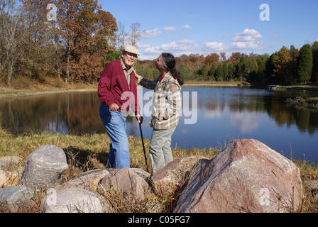 Senior couple enjoying temps ensemble par un lac à l'automne. Banque D'Images