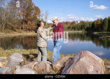 Heureux couple plus âgé par un lac. Banque D'Images