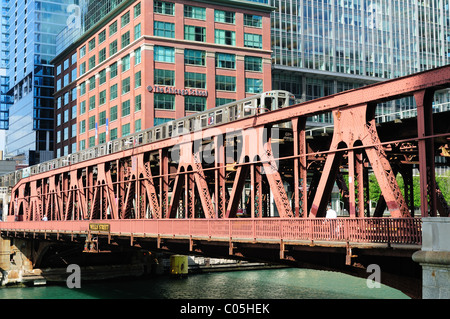 Une ligne brune CTA train surélevé traverse la rivière Chicago sur le pont de la rue des puits comme il se prépare à entrer dans la boucle de Chicago, Illinois, USA. Banque D'Images