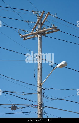 Poteau téléphonique en bois avec des lignes électriques et la lumière Banque D'Images