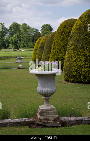 Trois urnes en pierre contenant des fleurs dans les jardins en terrasses de Shugborough Hall, précédent accueil de Lord Patrick Lichfield Banque D'Images