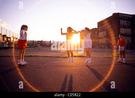 Corde à sauter enfants jouant sur la cour de l'école aire de jeux, Philadelphia, Pennsylvania, USA Banque D'Images