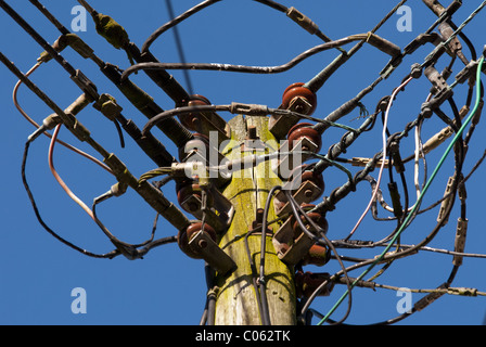 'Un poteau télégraphique' avec de nombreux câbles d'alimentation ou de l'utilitaire généraux fils sur elle, contre un ciel clair. Banque D'Images