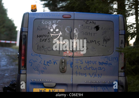 Bleu très sale travailleurs Vauxhall van avec graffiti écrit sur les portes arrière dans la terre. Banque D'Images