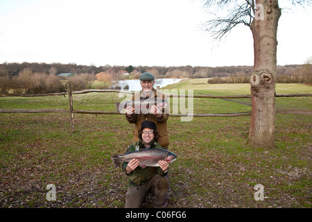 Avec les pêcheurs à la grosse truite arc-en-Blackwool Farm pêche à l'omble. Petworth, West Sussex, Angleterre, Royaume-Uni. Banque D'Images