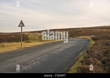 Signe de courbure sur une étroite route de campagne traversant une lande dans Yorkshire du Nord. Au-dessus de Swaledale Ellerton (Grinton à Leyburn Road) Banque D'Images