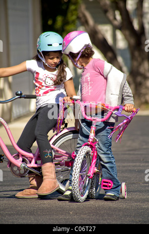 Une fille de cinq ans apprend à monter son nouveau vélo dans un coffre-fort parking à Laguna Niguel, CA. Banque D'Images