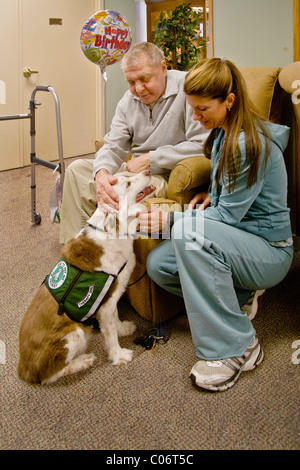 Une femme bénévole de bienfaisance introduit un chien de thérapie d'un patient dans une maison de retraite à Mission Viejo, en Californie. Presse Banque D'Images
