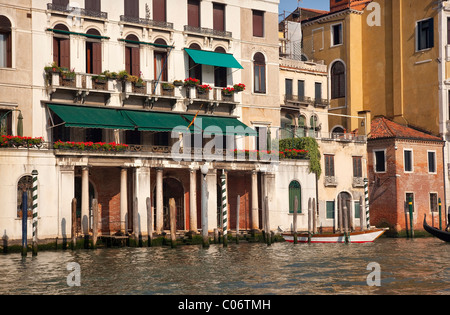Grand Canal Fleurs rouge bateau blanc balcons maisons poteaux gondole Réflexions Venise Italie Banque D'Images