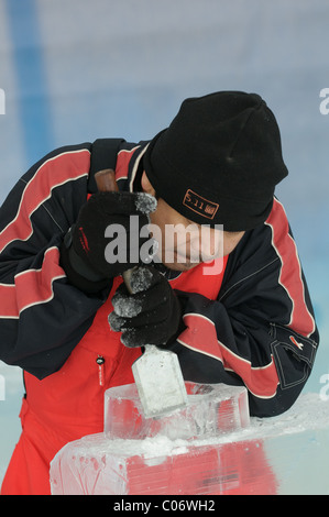 Des équipes de sculpteurs sur glace professionnel travailler ensemble à construire des sculptures de glace massive basée sur le thème "Yin et Yang" au bal. Banque D'Images