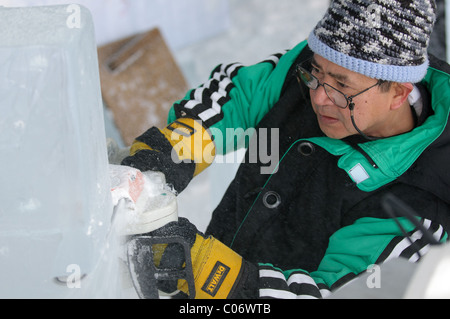 Des équipes de sculpteurs sur glace professionnel travailler ensemble à construire des sculptures de glace massive basée sur le thème "Yin et Yang" au bal. Banque D'Images