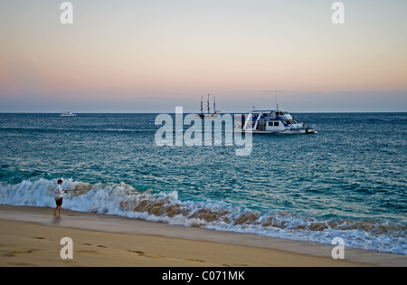 Pêche à la fin de soirée de la rive de l'océan pacifique vague voile Location de canne à pêche homme plage de sable Banque D'Images