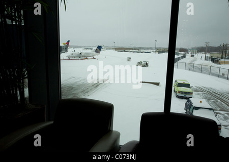 L'enlèvement de la neige sur le tarmac commence la fermeture de l'aéroport international de Bradley comme une tempête importante commence à s'apaiser. Banque D'Images