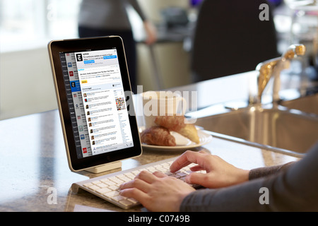 Femme lisant les flux Twitter page sur un iPad connecté via la technologie sans fil Bluetooth Banque D'Images