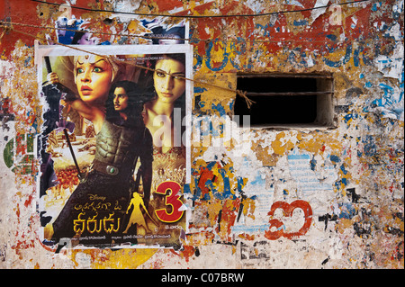 Affiches de films indiens sur un mur en lambeaux d'une vieille maison de l'Inde rurale. L'Andhra Pradesh, Inde Banque D'Images