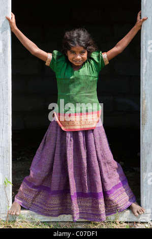 Happy young Indian street girl smiling standing dans une porte. L'Andhra Pradesh, Inde Banque D'Images