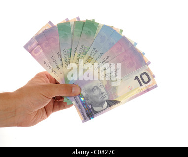 Main tenant une fan de divers billets en dollars canadiens Banque D'Images