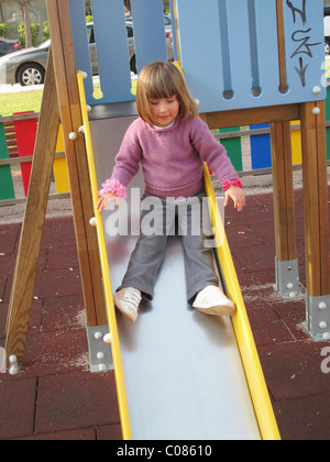 Trois ans et demi enfant sur sol glissant glisser dans Jeux pour enfants Banque D'Images