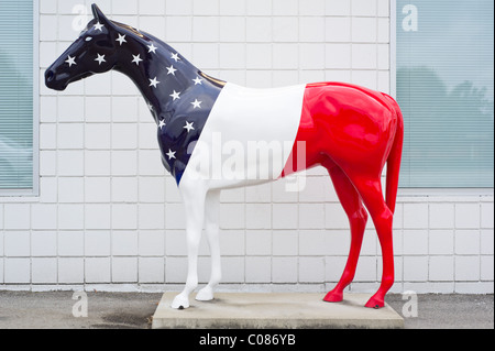 Statue cheval patriotique peinte en rouge, blanc et bleu avec des étoiles dans un drapeau américain, thème corps pleine vue de côté. Banque D'Images