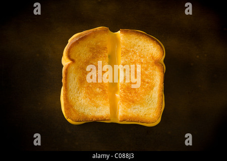 Un sandwich au fromage coupé en deux en tirant le fromage sur une table en bois Banque D'Images