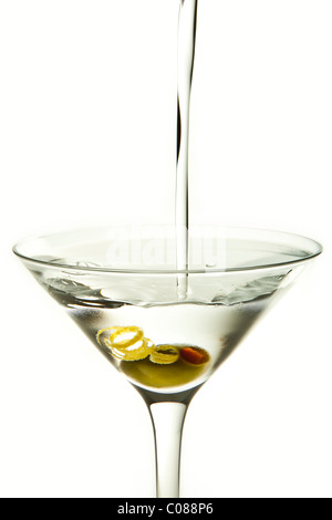 Un verre de cocktail Martini Olive et garnir avec le verser sur un fond blanc. Banque D'Images