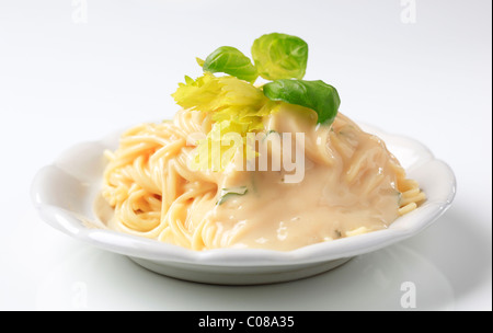 Spaghetti avec sauce crémeuse garnie de basilic frais Banque D'Images