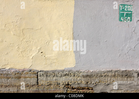 Panneau vert sur un mur de couleur jaune et gris Banque D'Images