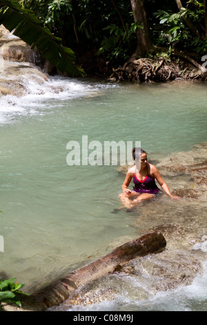 Belle femme assise se reposant dans un bassin peu profond d'eau après l'ascension de la Falls à Ocho Rios, Jamaïque. Banque D'Images