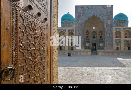 Le Mir-i-arab Madrassah vus à travers les portes de la mosquée Kalon, Boukhara, Ouzbékistan Banque D'Images