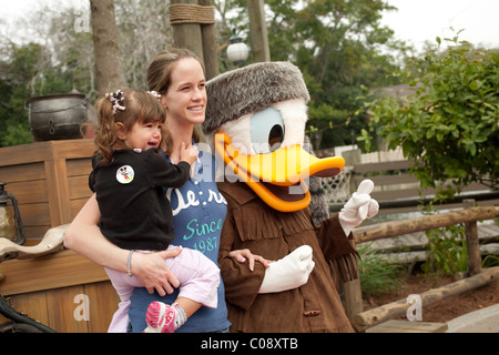 Enfant pleurant se fait prendre en photo avec maman et Donald Duck dans Frontierland, situé dans la région de parc à thème Disney's Magic Kingdom. Banque D'Images