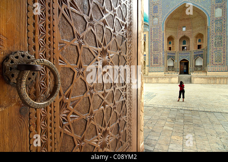 Le Mir-i-arab Madrassah vu au-delà les portes sculptées de la mosquée Kalon, Boukhara, Ouzbékistan Banque D'Images