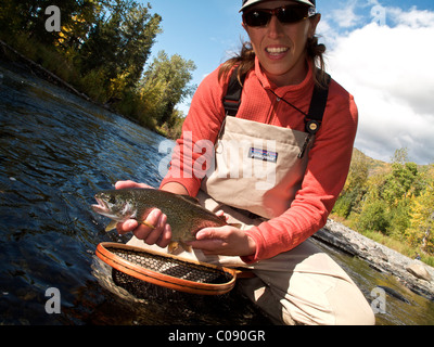 Femme et montre un arc-en-ciel Truite capturée alors que la pêche à la mouche sur la rivière russe, péninsule de Kenai, Southcentral Alaska Banque D'Images