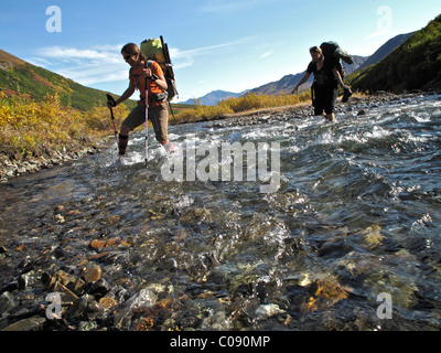 Deux randonneurs avec les bâtons de marche le long du ruisseau de vent traverse le Sanctuaire River Trail dans le parc national Denali, Alaska Banque D'Images