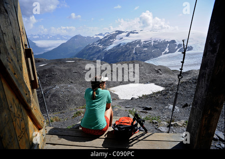 Backpacker femelle jouit du point de vue d'un chalet de montagne le long de la Harding Icefield trail, Kenai Fjords National Park, Alaska Banque D'Images