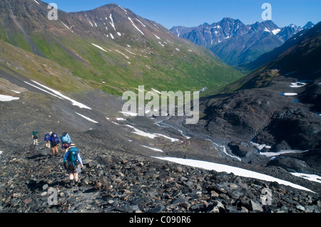 Un des randonneurs font leur chemin à l'écart de la descente du Glacier Raven Crow Pass, Chugach State Park, Southcentral Alaska Banque D'Images