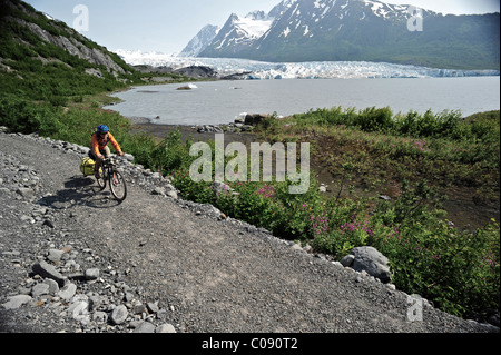 Femme de la bicyclette sur la piste vers Spencer, Glacier, la Forêt Nationale de Chugach péninsule de Kenai, Southcentral Alaska, l'été Banque D'Images