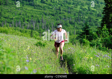 Female jogger exécute le point à proximité de sentier du parc d'état de Chugach, près d'Anchorage, Southcentral Alaska, l'été Banque D'Images