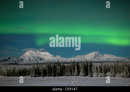 Aurora Borealis vert s'allume le ciel nocturne au-dessus de Mt. Sanford et de Mt. Drum dans les monts Wrangell, près de Kenny Lake, Alaska Banque D'Images