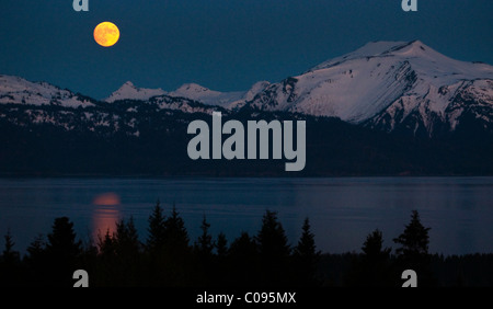 Vue d'une pleine lune qui s'élève au-dessus de Kachemak Bay près de Homer, Kenai Peninsula, Southcentral Alaska, printemps Banque D'Images