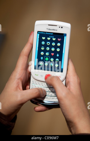 Fille à l'aide de Blackberry messenger sur un terminal Blackberry 9800 Torch Banque D'Images