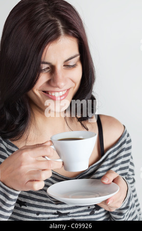 Smiling young brunette woman détient tasse de café Banque D'Images