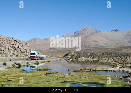 Chariot sur une route, la végétation, les montagnes, les grottes de Las Cuevas, la CONAF, parc national de Lauca, Altiplano, Norte Grande Banque D'Images